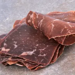 Fines tranches de viande de grison, d'origine suisse, avec leur persillage caractéristique.