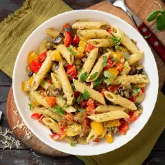 Un plat coloré de penne aux légumes grillés, parfait pour manger des pâtes avec plaisir.