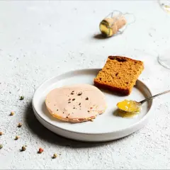 Tranche de foie gras sur assiette avec pain d'épices et confiture. La question "foie gras à partir de quel âge" reste ouverte.