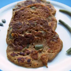 Galettes de patate douce sans gluten, parsemées de graines de courge, avec des haricots verts.