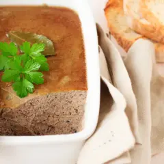 Terrine de campagne garnie de persil, prête à être dégustée avec des toasts. Une belle illustration de la différence entre terrine et pâté.