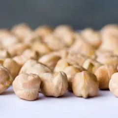 Grains de pois chiche, rappelant leur origine méditerranéenne, sur un fond flou.