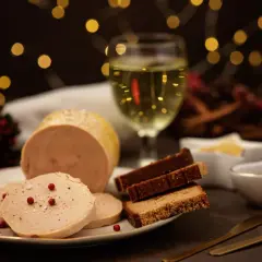 Foie gras maison servi avec du pain d'épices et une coupe de vin blanc. Quel alcool pour foie gras maison ? Un vin doux naturel ou un Sauternes serait parfait.