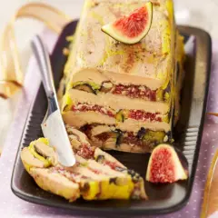 Un pressé de foie gras aux figues, une tranche est coupée, prête à être dégustée.