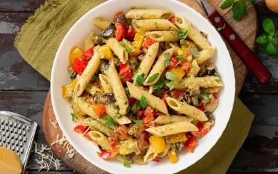 Un plat coloré de penne aux légumes grillés, parfait pour manger des pâtes avec plaisir.