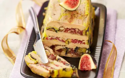 Un pressé de foie gras aux figues, une tranche est coupée, prête à être dégustée.