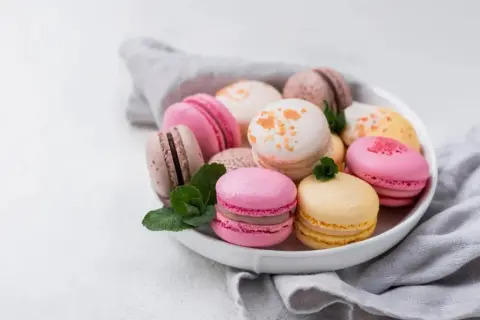 Un assortiment coloré de macarons, évoquant la douceur et l'origine française de ces délices.