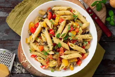 Un plat coloré de penne aux légumes grillés, parfait pour manger des pâtes avec plaisir.