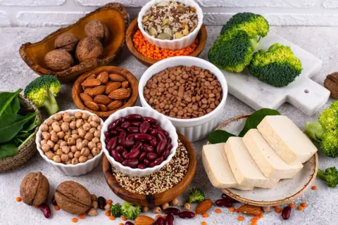 Un assortiment de protéines végétales : haricots rouges, lentilles, pois chiches, amandes, noix, tofu, brocolis et épinards. Le haricot rouge bienfait est un allié santé.