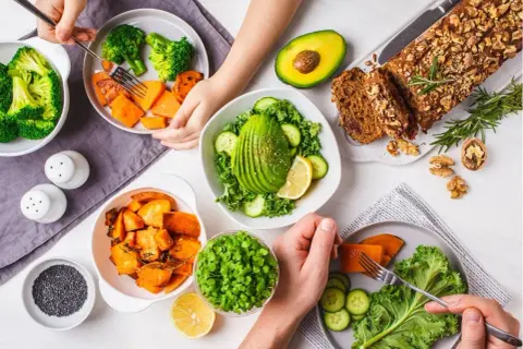 Un repas sain avec des légumes riches en fibres : brocolis, patates douces, avocat, chou frisé, concombre et pousses.