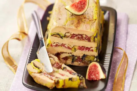 Un pressé de foie gras aux figues, une tranche est coupée, prête à être dégustée.
