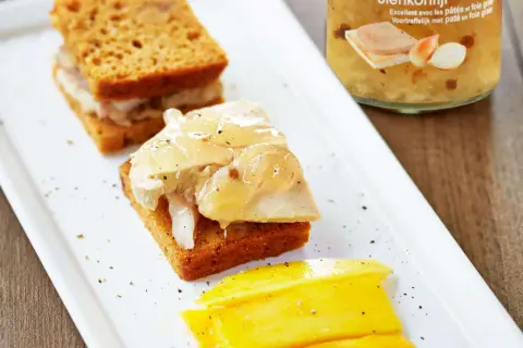 Toast de pain d'épice garni de foie gras et de confit d'oignons, accompagné de mangue.