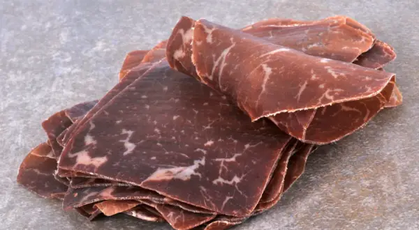 Fines tranches de viande de grison, d'origine suisse, avec leur persillage caractéristique.