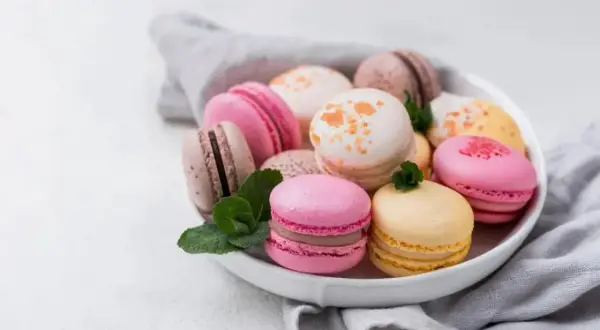Un assortiment coloré de macarons, évoquant la douceur et l'origine française de ces délices.