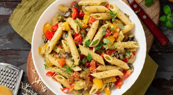 Un plat coloré de penne aux légumes grillés, parfait pour manger des pâtes avec plaisir.