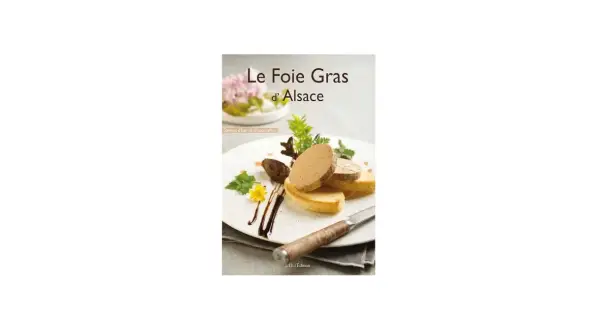 Tranches de foie gras sur toasts, garnies de verdure et d'une fleur jaune, sur une assiette blanche.