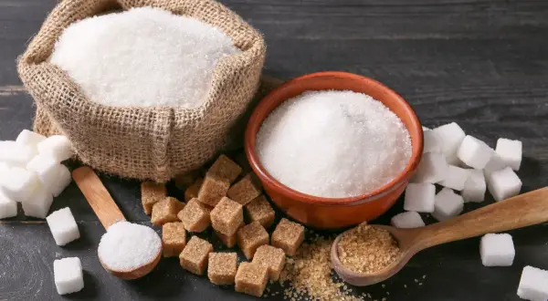 Sache de sucre blanc, bol, morceaux de sucre blanc et brun, cuillères. Le sucre raffiné, c'est quoi ? Une question de goût et de transformation.
