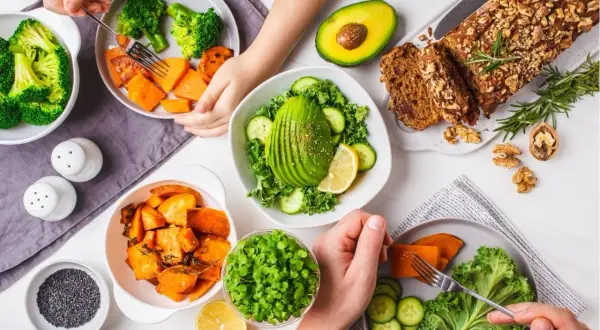 Un repas sain avec des légumes riches en fibres : brocolis, patates douces, avocat, chou frisé, concombre et pousses.
