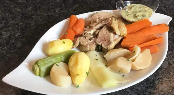 Plat de tête de veau avec carottes, pommes de terre, poireaux et une sauce pour tête de veau crémeuse.