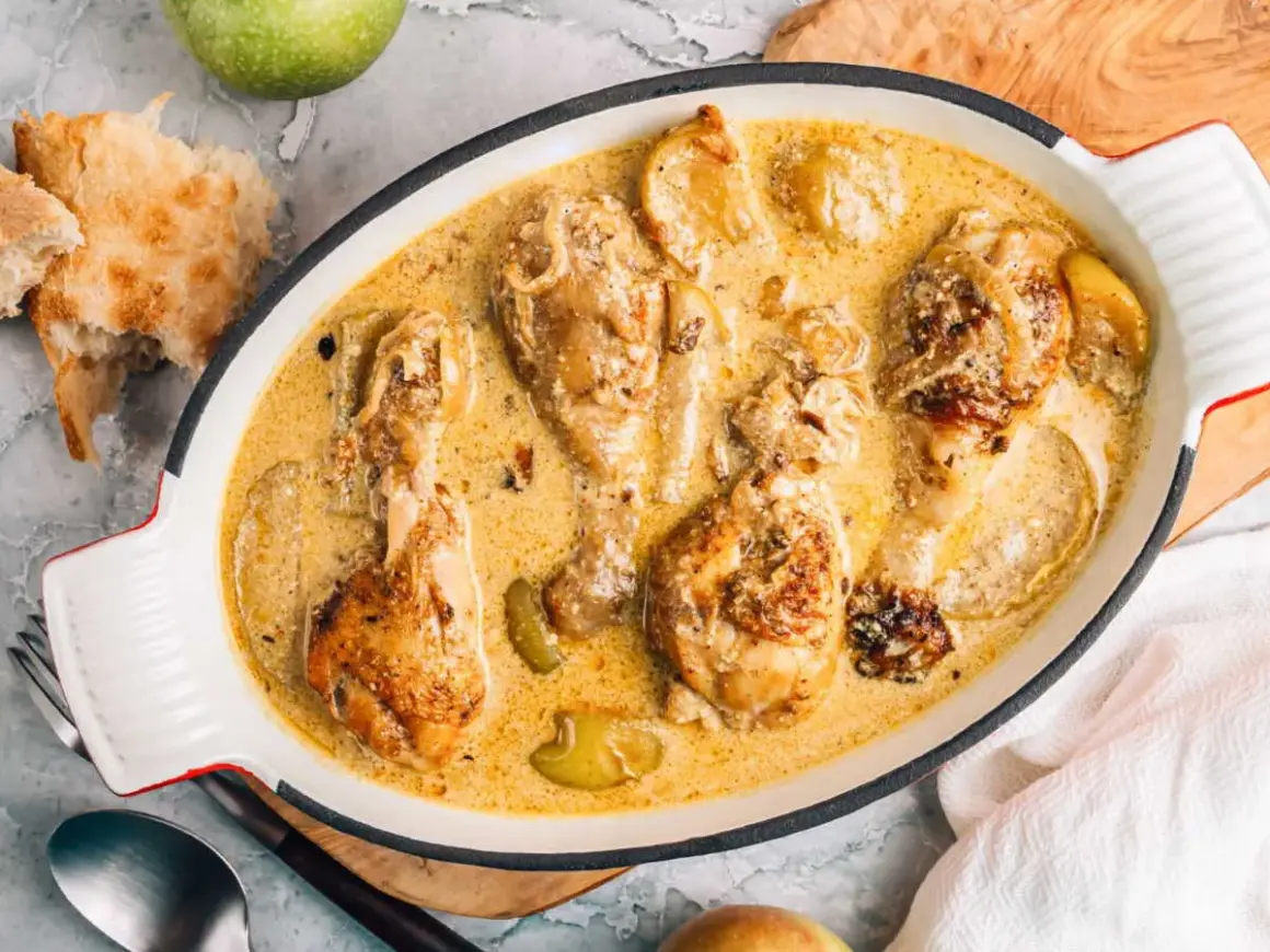 Poularde de Bresse en sauce crémeuse, une recette savoureuse avec des morceaux de poulet dorés et des pommes.