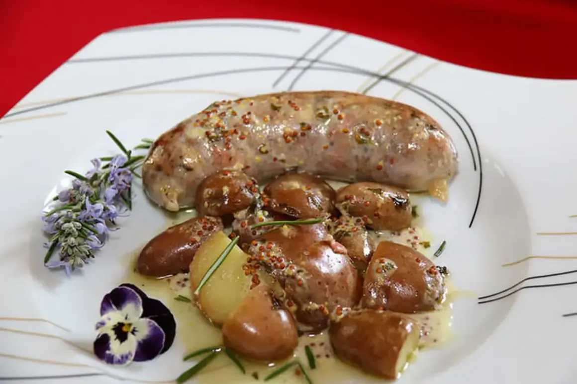 Une andouillette sauce moutarde, accompagnée de pommes de terre grenaille et d'une touche de romarin et de pensée.