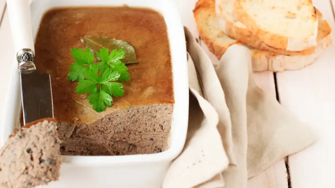 Terrine de campagne garnie de persil, prête à être dégustée avec des toasts. Une belle illustration de la différence entre terrine et pâté.