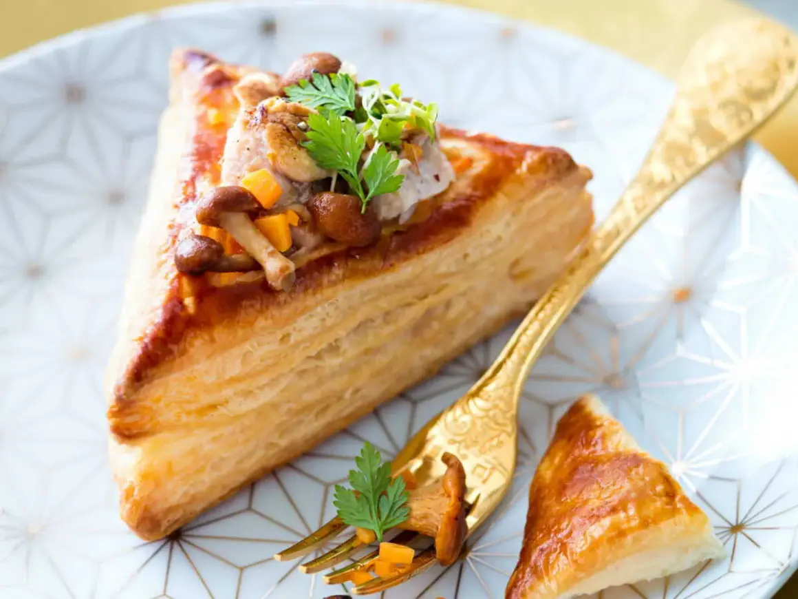 Délicieux feuilleté de ris de veau garni de champignons et de légumes croquants, servi sur une assiette ornée.