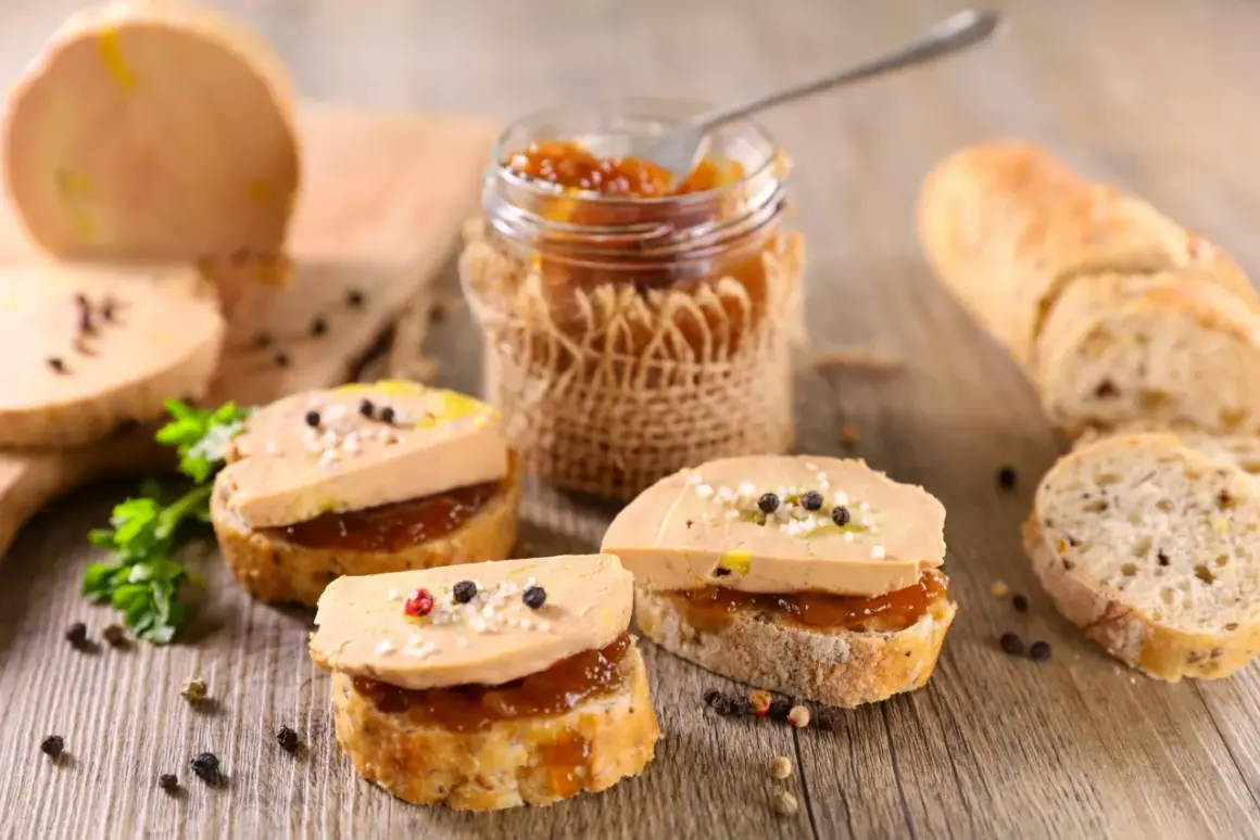 Tranches de pain garnies de foie gras et de confiture, avec un pain à côté. Le foie gras calories est un sujet de discussion, mais ce délice est irrésistible.