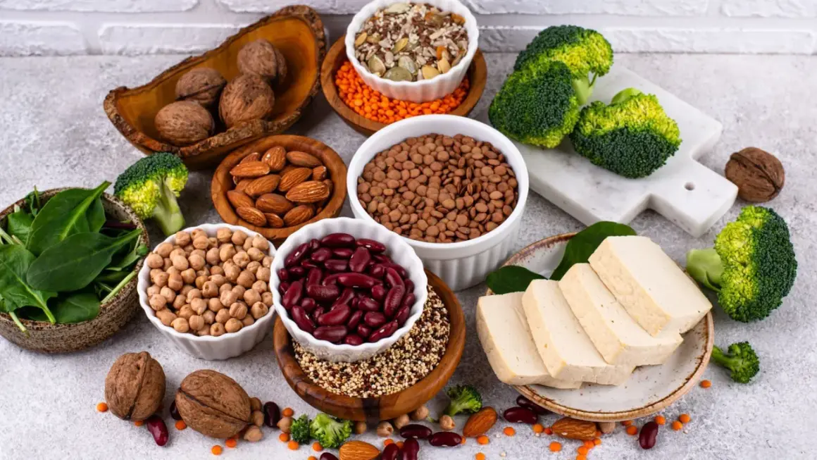 Un assortiment de protéines végétales : haricots rouges, lentilles, pois chiches, amandes, noix, tofu, brocolis et épinards. Le haricot rouge bienfait est un allié santé.
