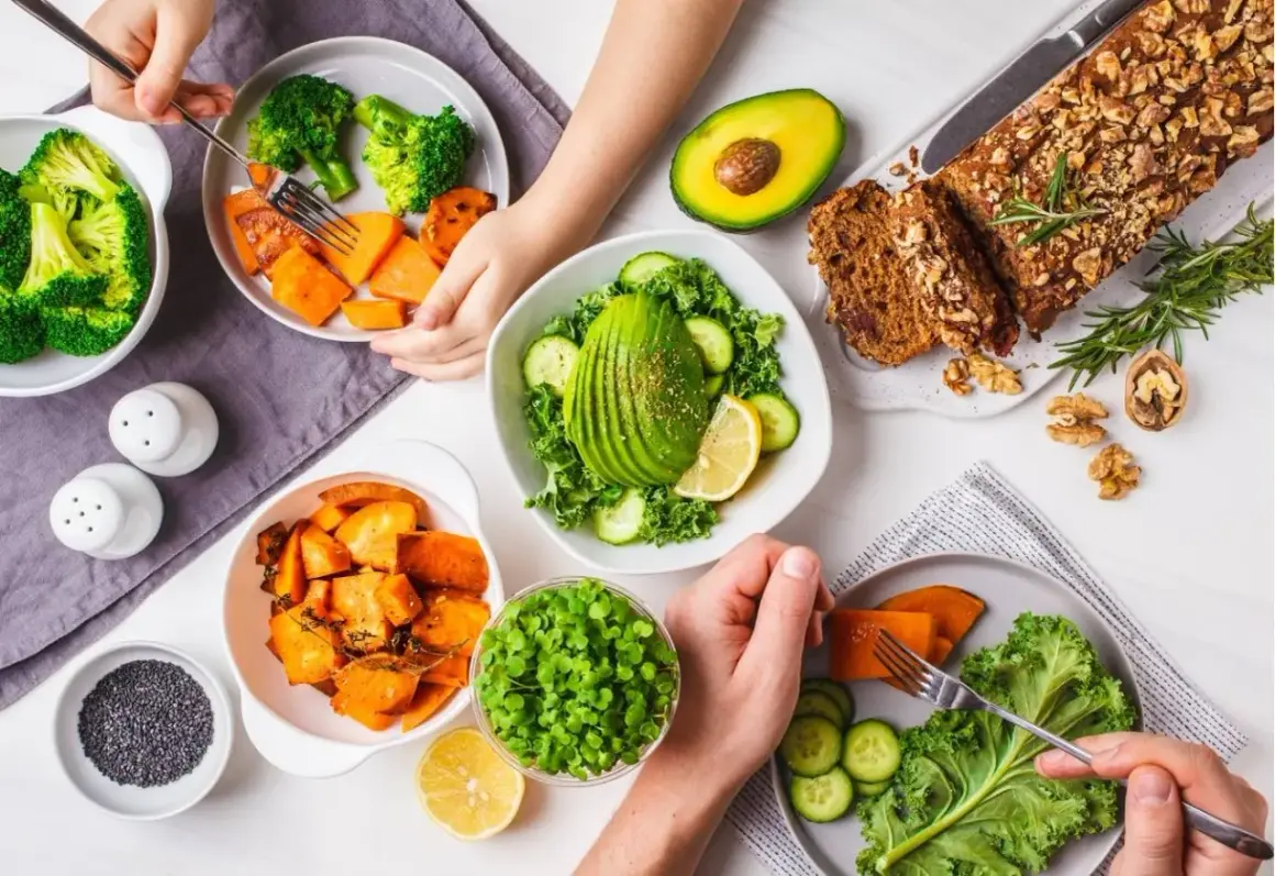 Un repas sain avec des légumes riches en fibres : brocolis, patates douces, avocat, chou frisé, concombre et pousses.