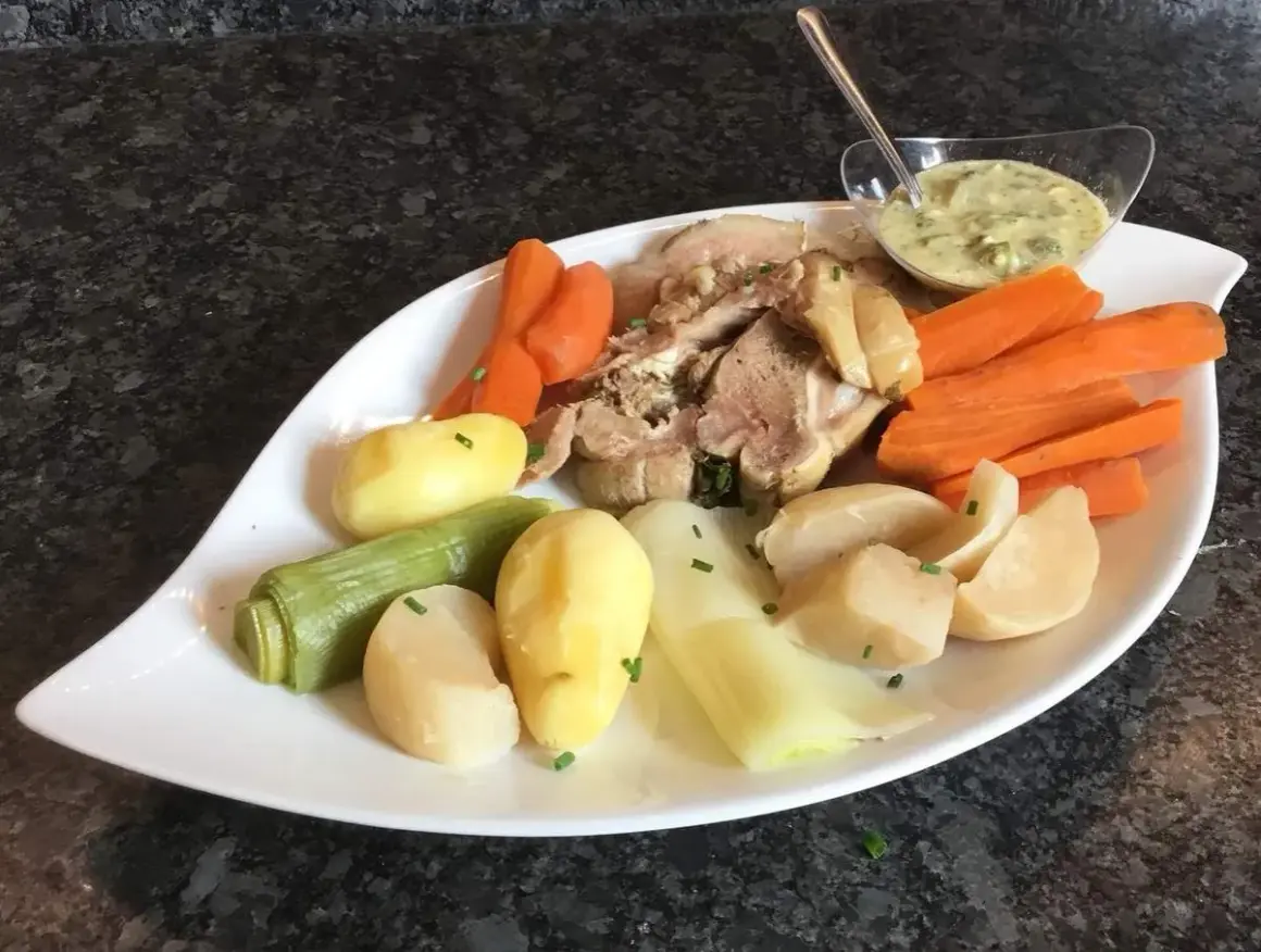 Plat de tête de veau avec carottes, pommes de terre, poireaux et une sauce pour tête de veau crémeuse.