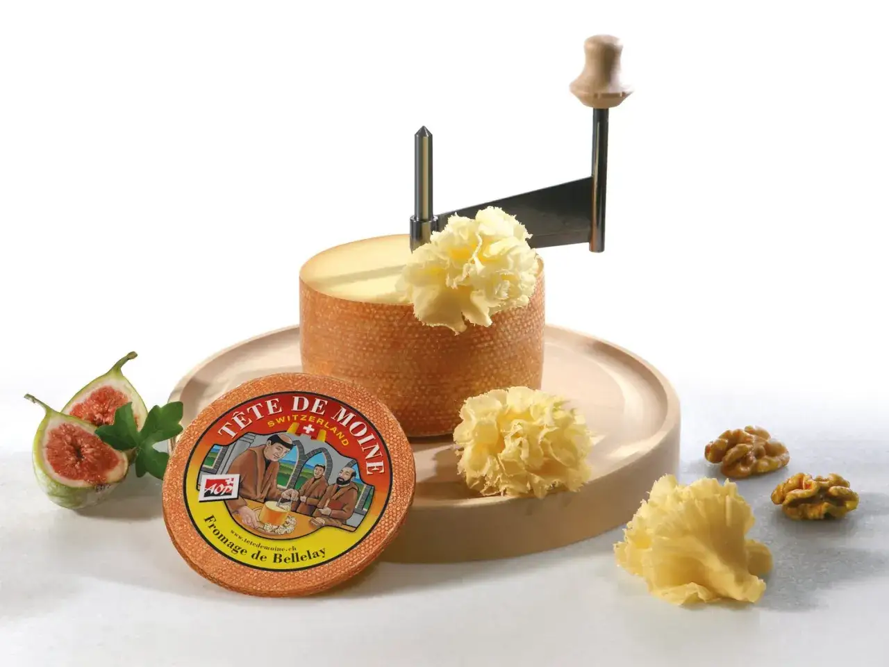 Fromage T&ecirc;te de Moine, un d&eacute;lice suisse, est pr&eacute;sent&eacute; avec sa girolle, des figues et des noix. L'origine de ce fromage est mise en avant.