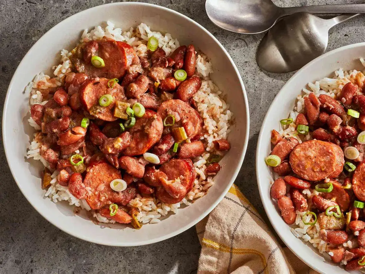Deux bols de riz avec haricots rouges et saucisses, garni de ciboule. Un plat savoureux qui rappelle les bienfaits du haricot rouge.