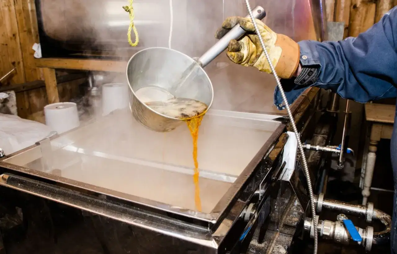 Un ouvrier verse du sirop d'&eacute;rable bouillant dans une &eacute;vaporatrice. Le sirop d'&eacute;rable, c'est quoi ? C'est le r&eacute;sultat de la transformation de la s&egrave;ve d'&eacute;rable.