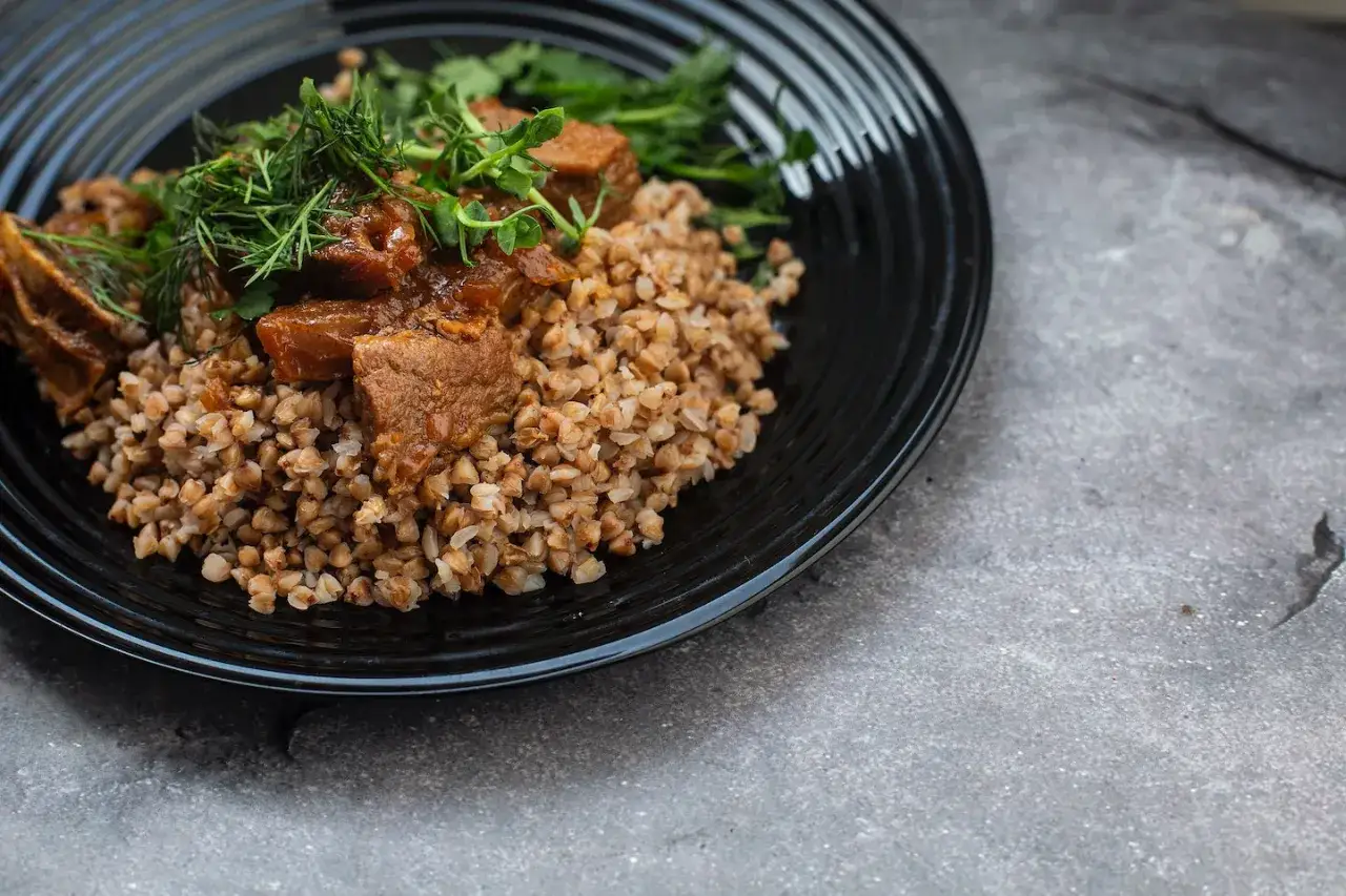 Un plat r&eacute;confortant de bl&eacute; noir garni de morceaux de viande mijot&eacute;e et d'herbes fra&icirc;ches.