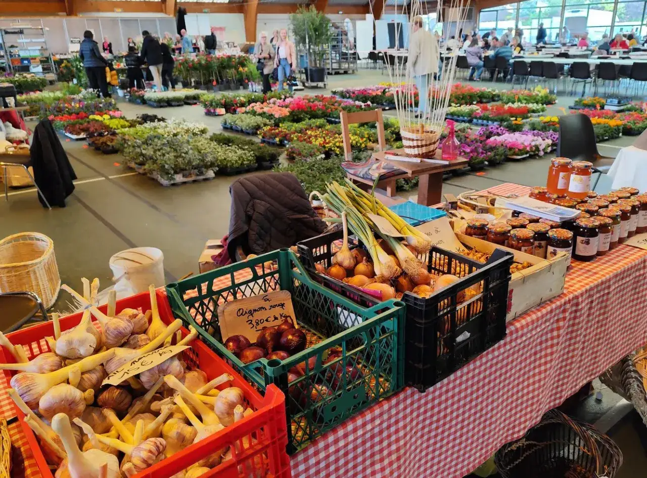 Ambiance de march&eacute; : oignons, ail, confitures et fleurs pour un terroir en f&ecirc;te.