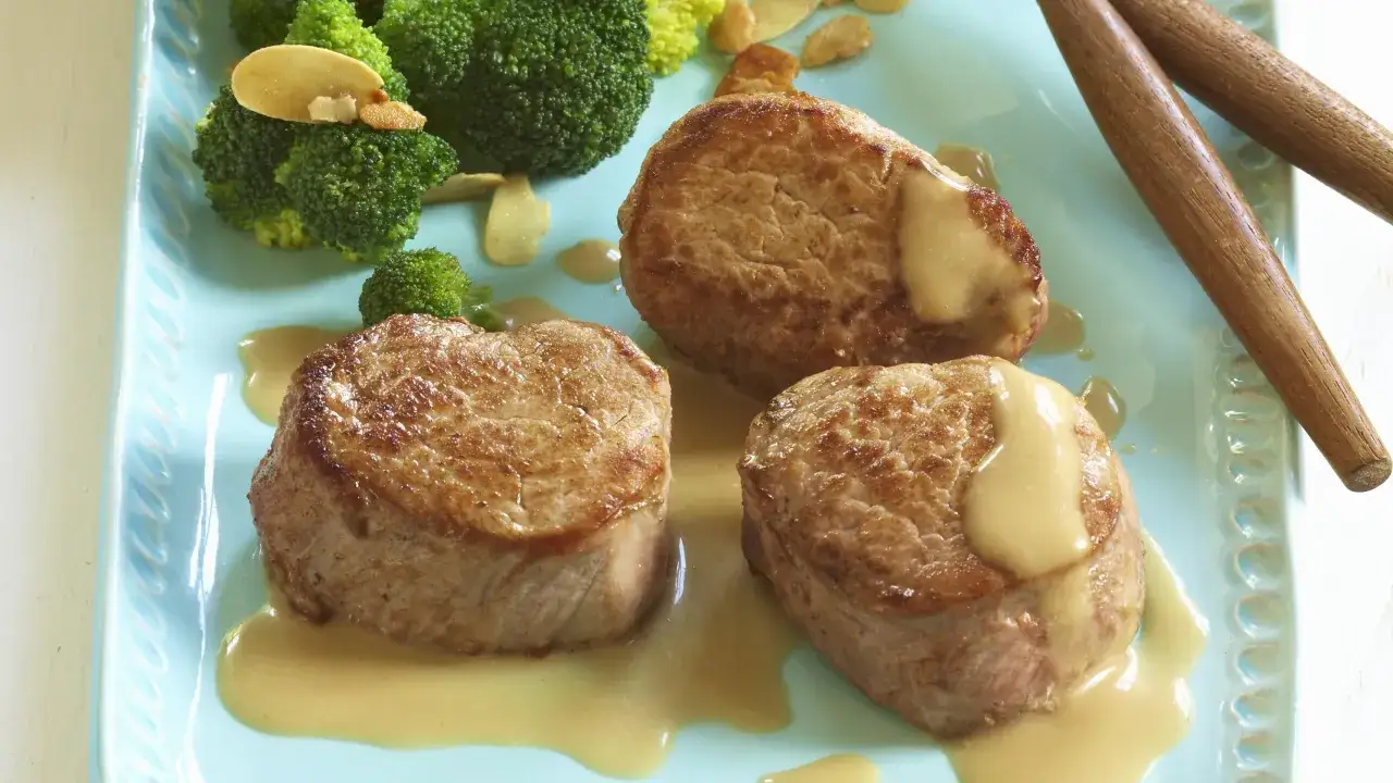 Trois m&eacute;daillons de porc napp&eacute;s de sauce, accompagn&eacute;s de brocolis et d'amandes effil&eacute;es. Une belle pr&eacute;sentation pour une recette m&eacute;daillon de porc.