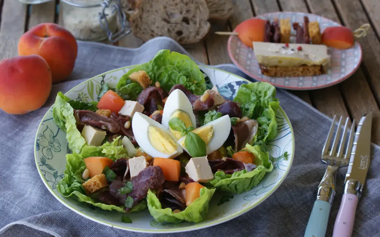 Salade périgourdine colorée avec œufs, magret, fruits et croûtons. Un délice pour les papilles !