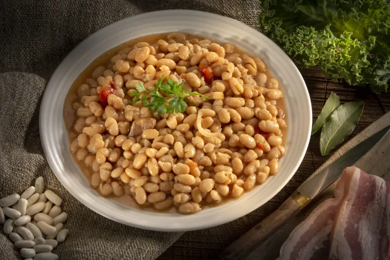 Un plat de haricots blancs mijot&eacute;s, garni de persil. Le haricot blanc bienfait est un aliment sain et nourrissant, parfait pour un repas r&eacute;confortant.