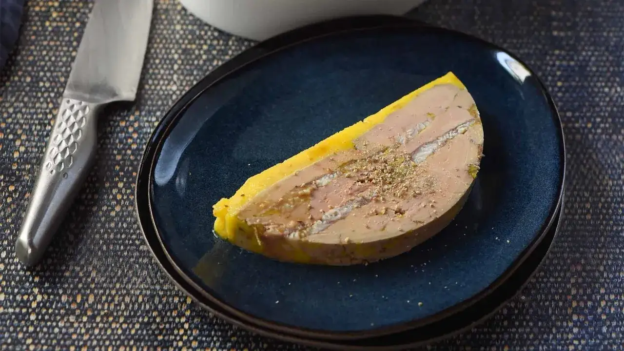 Tranche de foie gras, un mets d&eacute;licat, sur une assiette bleue. Ce plat, souvent servi en entr&eacute;e, est une sp&eacute;cialit&eacute; fran&ccedil;aise.