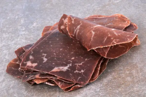Fines tranches de viande de grison, d'origine suisse, avec leur persillage caractéristique.