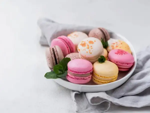 Un assortiment coloré de macarons, évoquant la douceur et l'origine française de ces délices.