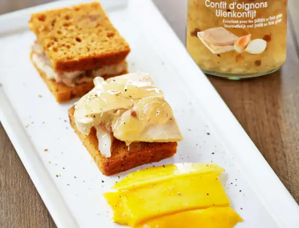 Toast de pain d'épice garni de foie gras et de confit d'oignons, accompagné de mangue.